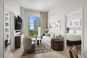 A modern hotel room with a sofa, armchair, coffee table, and a bed. - Stylish 1BR Condo | Domus Brickell (Miami)