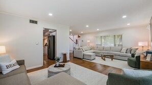 Een moderne woonkamer met een bank, een salontafel en een eethoek.