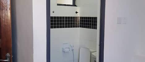 A bathroom with a toilet, a mirror, and a towel rack.