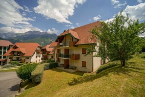 Ein Hotel mit mehreren Gebäuden, Balkonen und einer Bergkulisse.