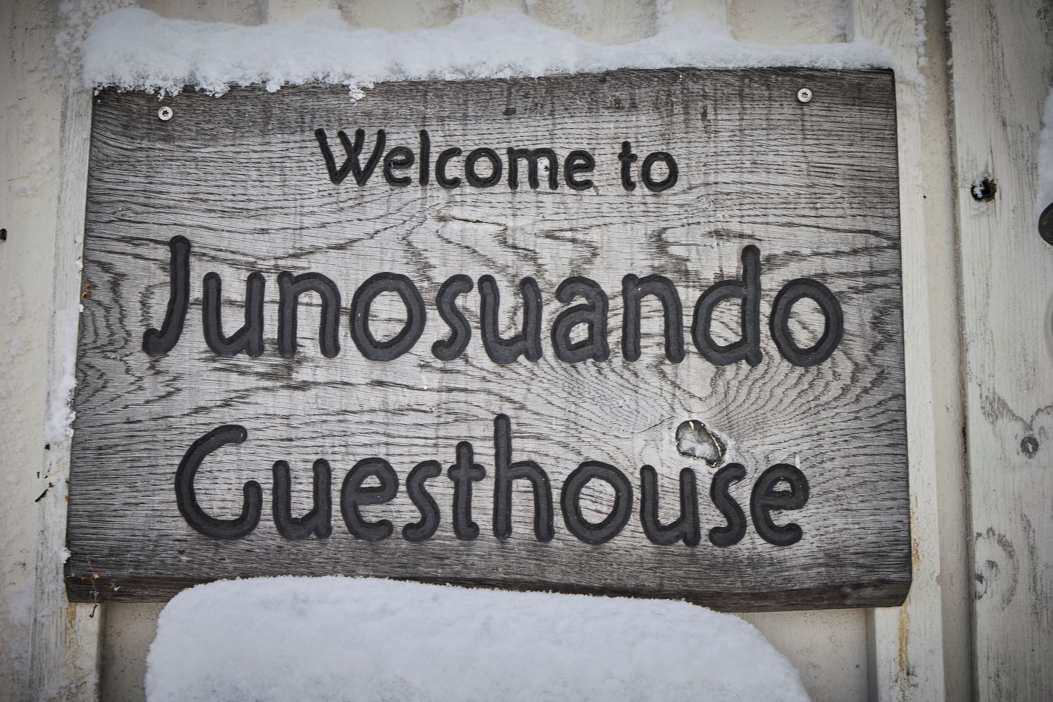 Un cartello di legno con la scritta 'Welcome to Junosando Guesthouse'.