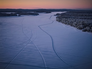 Un vaste paysage gelé, parsemé de traces de pneus.