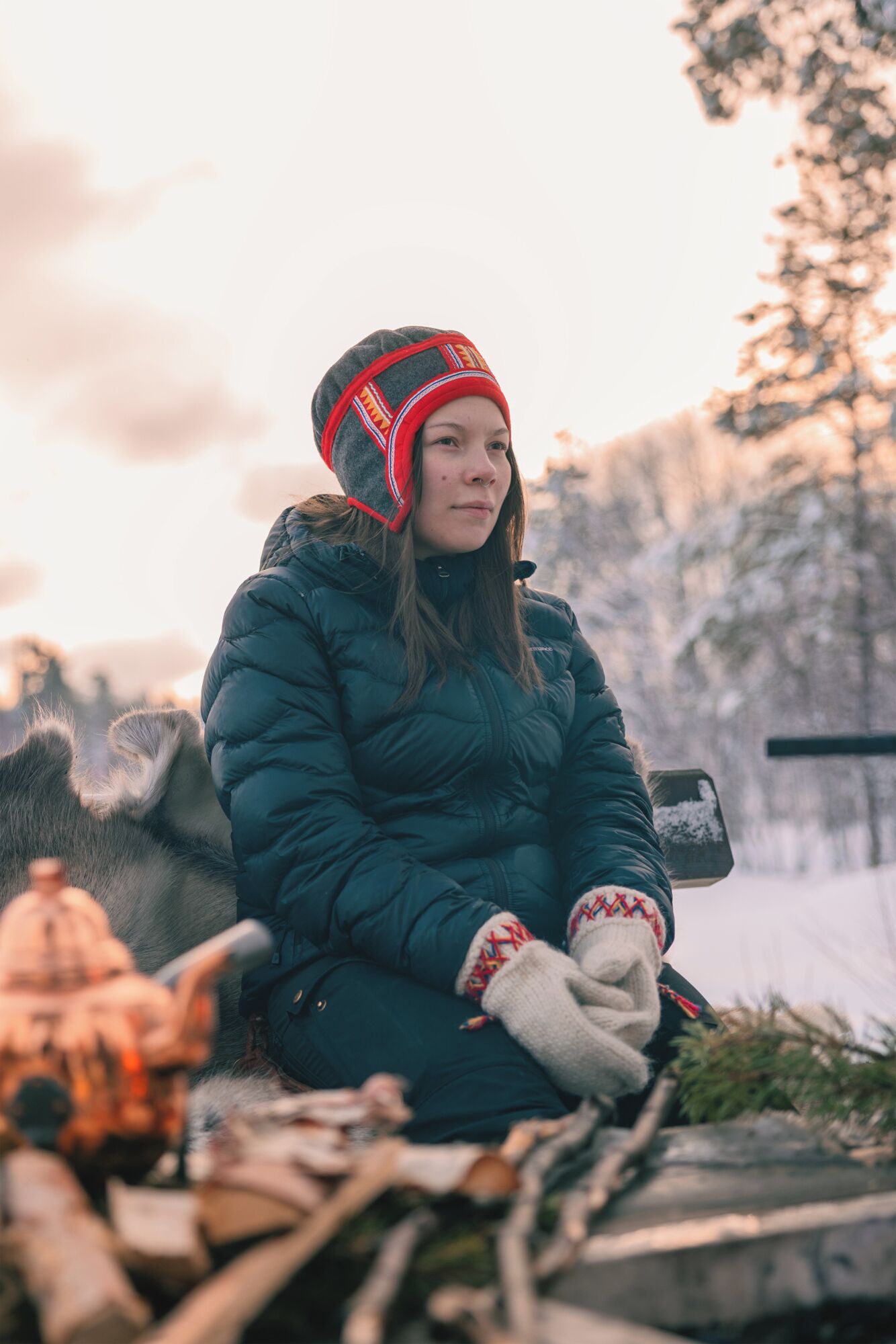 A person sitting outdoors in winter clothing.