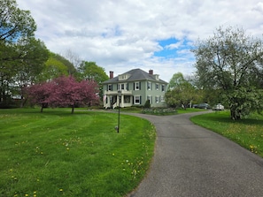 A two-story house with a front porch and a driveway leading to the entrance.