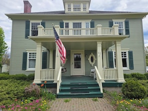 A two-story house with a porch, a flag, and a mailbox. - The Marr House on the River (Greene)