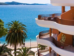 A multi-story building with balconies overlooking a beach and sea. - Hotel Vale (Sarande)