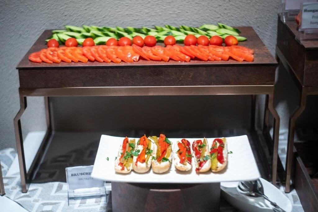 A buffet table with sliced vegetables and a plate of appetizers.