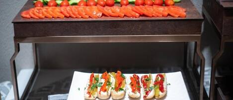 Una mesa de buffet con verduras cortadas y un plato de aperitivos.