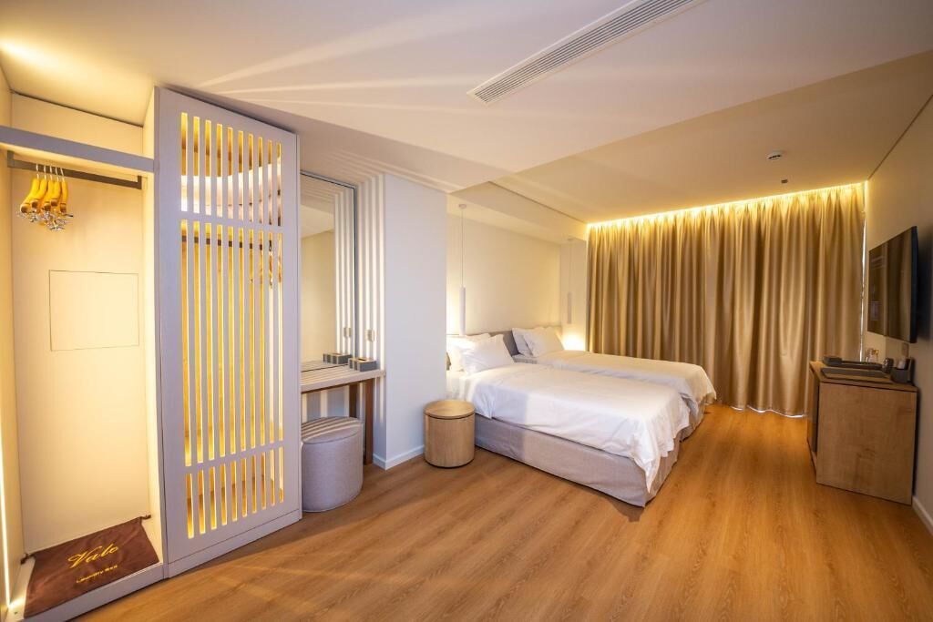 A hotel room with a bed, a wardrobe, a television, and a mirror.