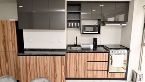 A modern kitchen with wooden cabinets, a built-in microwave, a stove, and a sink. - Luxury Penthouse in Polanco | Private Terraces + Prime Location (Ciudad de México)