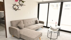 A modern living room with a sofa, a small table, and decorative shelves. - Luxury Penthouse in Polanco | Private Terraces + Prime Location (Ciudad de México)