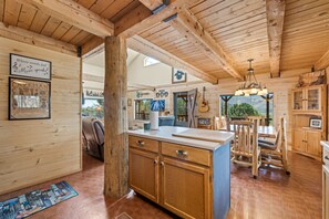 A rustic interior with wooden beams, a kitchen area, and a dining space with a view. - Mountain Soul | ATV Access, Porch & Mountain Views (South Fork)