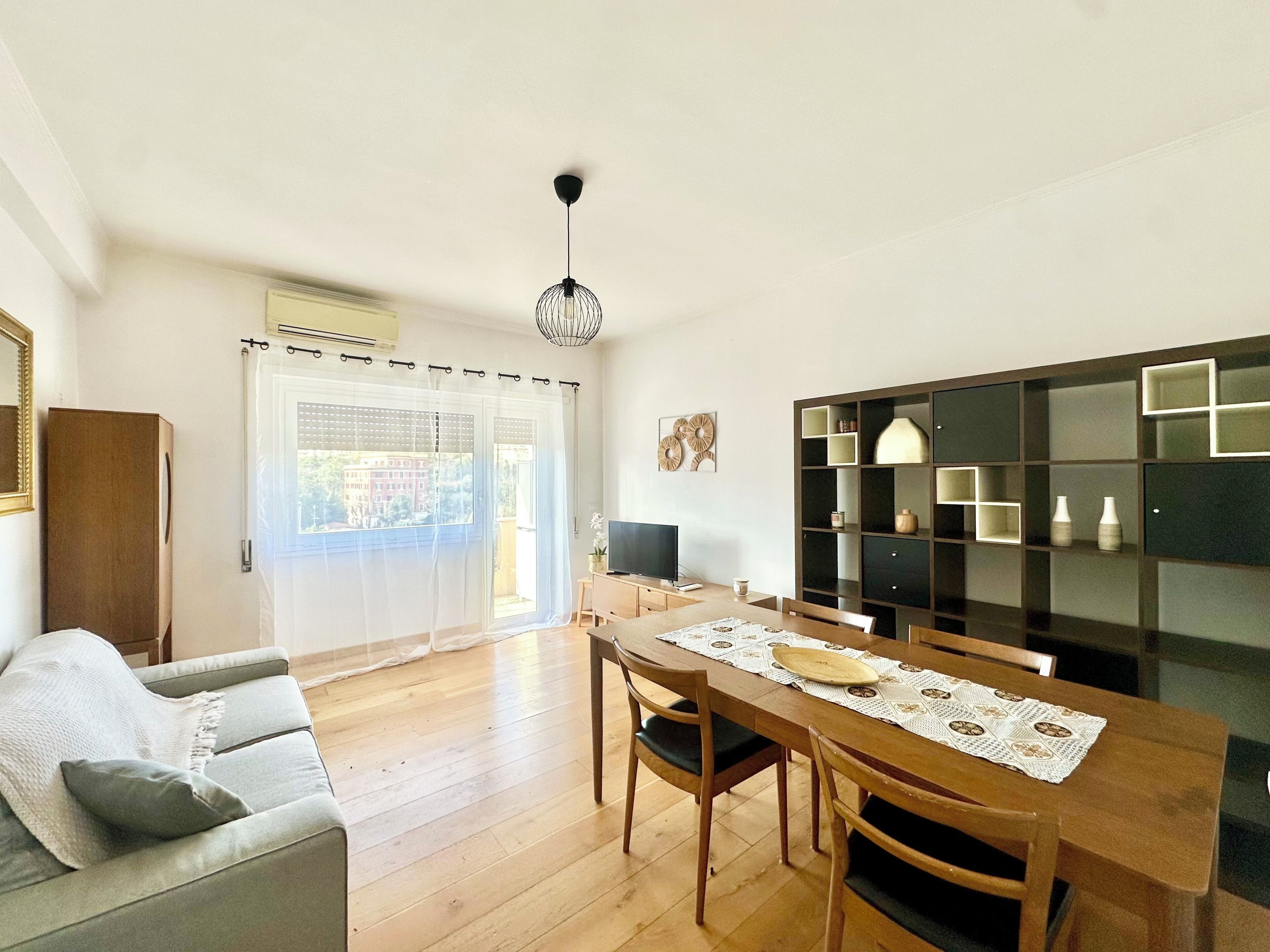 A dining area with a wooden table, chairs, and a ceiling light fixture. - Vatican St. Peter bright apartment (Roma)