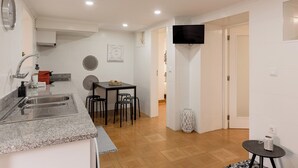 Eine moderne Küche mit Granit Arbeitsplatte, Spüle aus Edelstahl und einem Essbereich mit Tisch und Stühlen.