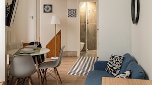 Een compacte, meerlaagse kamer met een stapelbed, een eethoek en een zithoek.