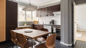 Una cocina moderna con una mesa de comedor, sillas e iluminación colgante.
