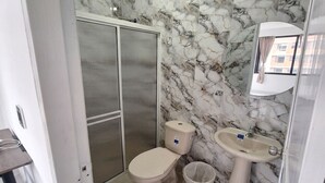 A bathroom with a toilet, sink, and shower.