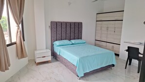 A bedroom with a bed, nightstand, wardrobe, and desk.