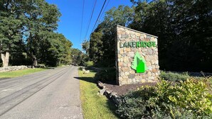 Uma estrada que leva a uma placa com o nome 'LAKERIDGE' e um símbolo de seta verde.