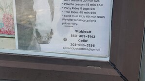 Placa de Lakeridge Stables anunciando aulas de equitação e colônias de férias.