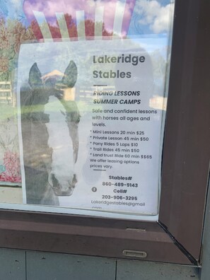 Señal de Lakeridge Stables que anuncia clases de equitación y campamentos de verano.