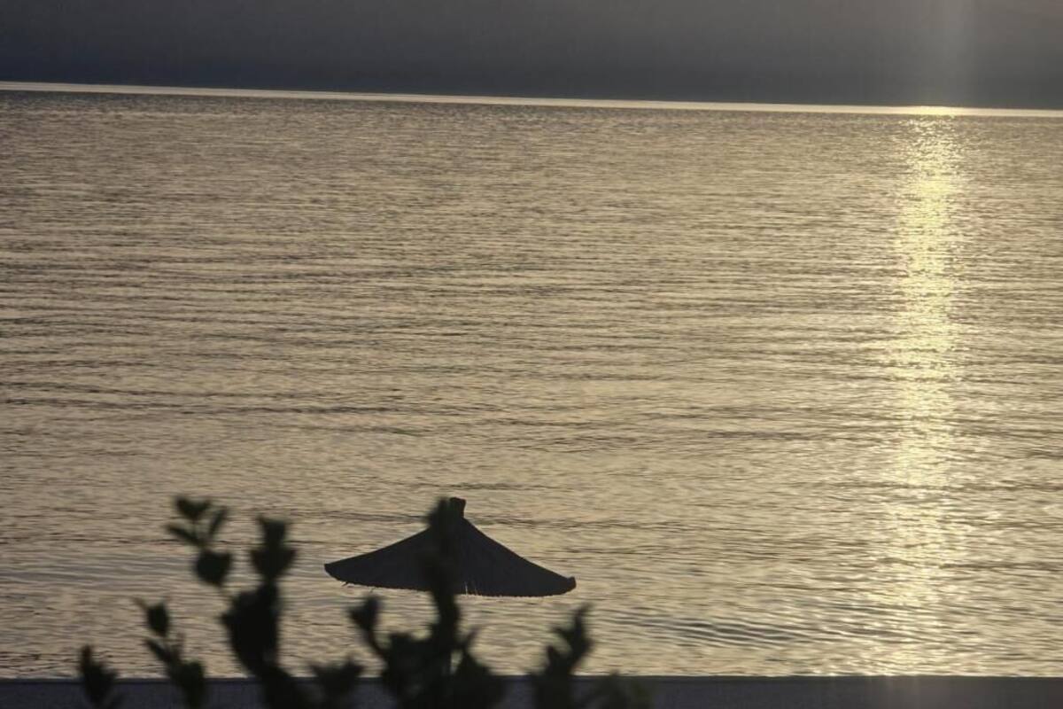 Un plan d’eau paisible, avec la silhouette d’une structure, peut-être un bâtiment ou un pavillon, au premier plan.