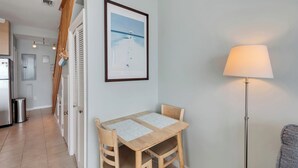 Un coin repas avec une table et des chaises, une lampe et un tableau encadré au mur.