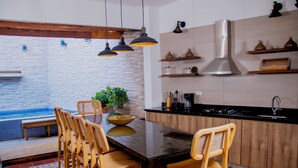 Een moderne keuken met houten kastjes, een zwart aanrecht en hangende pendellampen.