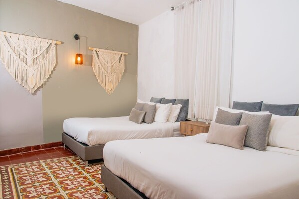 A hotel room with two beds, a patterned floor, macramé wall decorations, and a bedside lamp. - Casa Marta Getsemani - Colonial Villa with Private Pool by zakher (Cartagena)