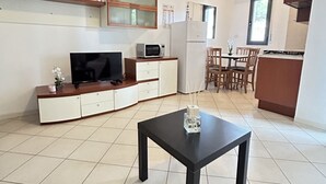 Une cuisine compacte équipée d’un four à micro-ondes, d’un réfrigérateur et d’un coin repas avec des chaises.