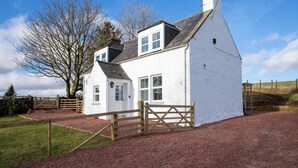 A white house with a wooden gate, a stone wall, and a tree in the background. - Luxury Scottish Cottage with Hot Tub & Views - Pass the Keys (Sanquhar)