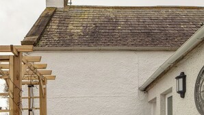 A hot tub in front of a house with a wooden pergola and a chimney. - Luxury Scottish Cottage with Hot Tub & Views - Pass the Keys (Sanquhar)