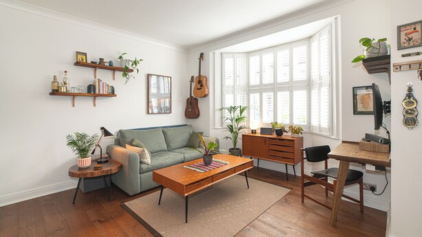 Ein Wohnzimmer mit einer Couch, einem Couchtisch und einem Essbereich mit Stuhl und Tisch.