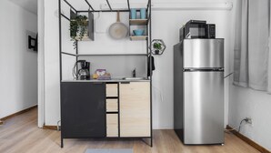 Une petite cuisine équipée comprenant une cuisinière intégrée, un four à micro-ondes et un réfrigérateur.