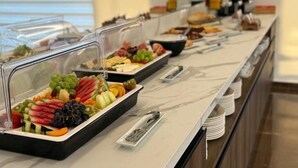 Un buffet proposant une variété de plats et d’ustensiles.