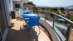 Un balcon avec une table et des chaises, une piscine et une vue sur le paysage.