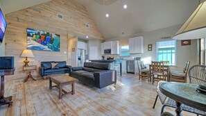 A spacious living area with a wooden ceiling, a sofa, a coffee table, and a dining table with chairs. - Pool, Boat Dock, Balcony w/ Bay Views Cooper's Hawk by Avantstay (Corpus Christi)