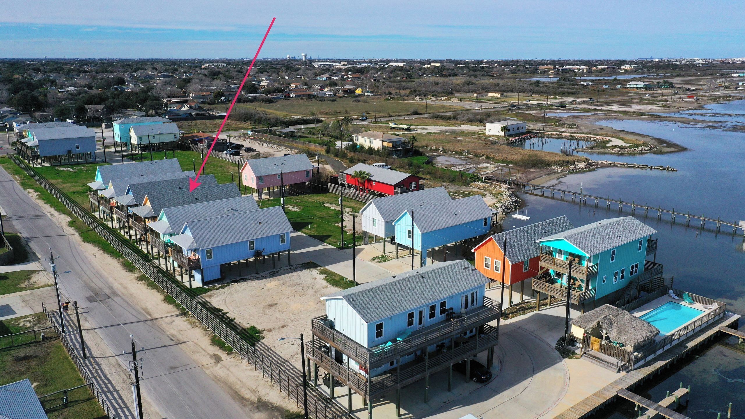 Una zona costera con casas sobre pilotes, un muelle y una vista despejada del agua.