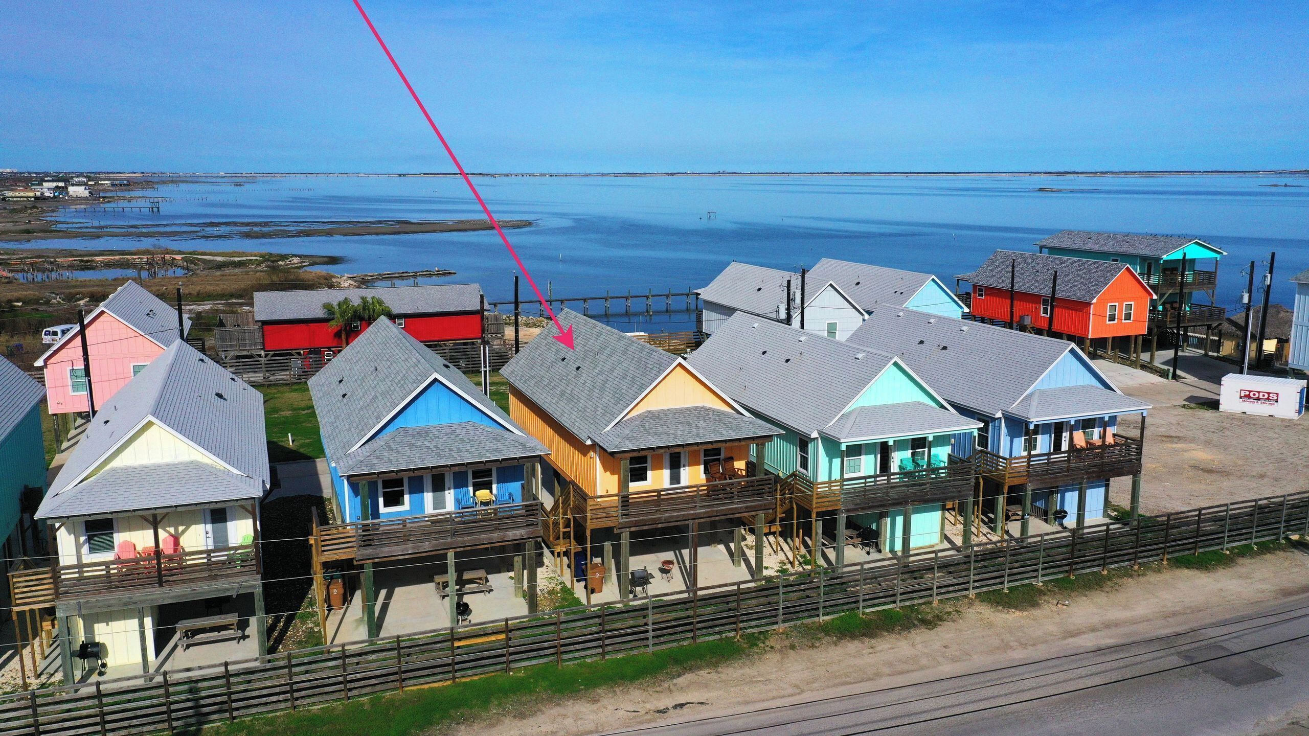 A coastal area with colorful houses, some with balconies, and a clear view of the water.