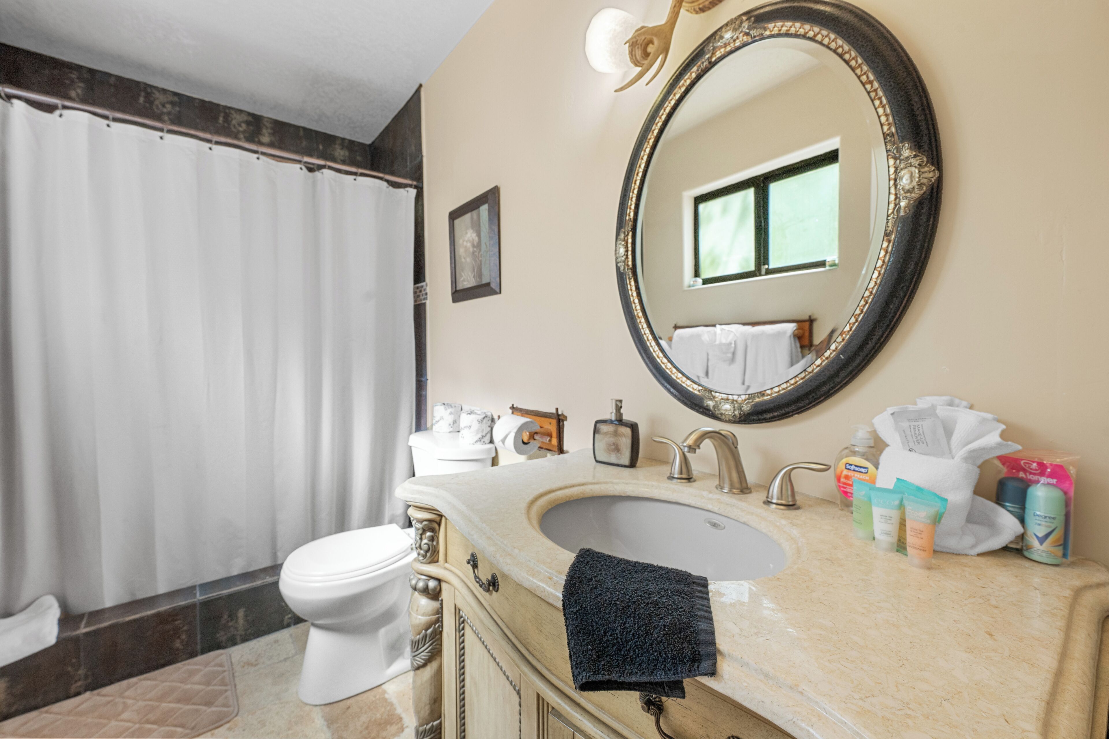 A bathroom with a bathtub, toilet, sink, and mirror.