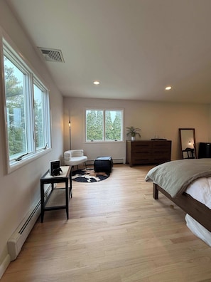 A bedroom with a bed, a chair, a dresser, a radiator, and a window with a view of trees. - Azur East,  southampton (Southampton)