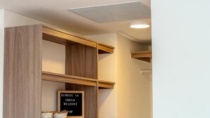 A modern closet with wooden shelves, a hanging light, and a welcome sign.