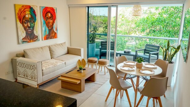 A modern living room with a sofa, coffee table, and dining table set for six.