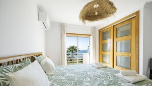 Une chambre à coucher avec un lit, une grande fenêtre et une vue sur la mer.