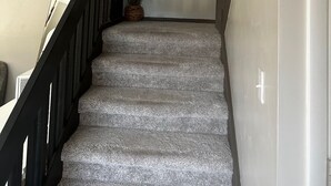 A staircase with a black railing, a potted plant, and a painting on the wall. - Exquisite gated private townhouse in the beautiful Palm Bay (Palm Bay)