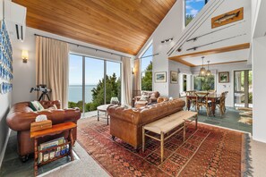 A spacious living area with a leather sofa, wooden coffee table, and a large rug.