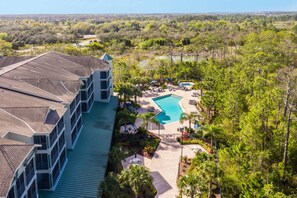Ein Hotel mit Pool auf dem Dach, umgeben von üppiger Vegetation und Blick auf die Landschaft.