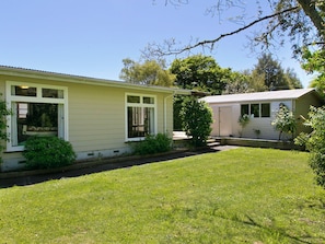 A two-story house with a front yard and a small garden.
