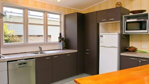 Una cocina equipada con lavavajillas, refrigerador, microondas y encimera de madera.