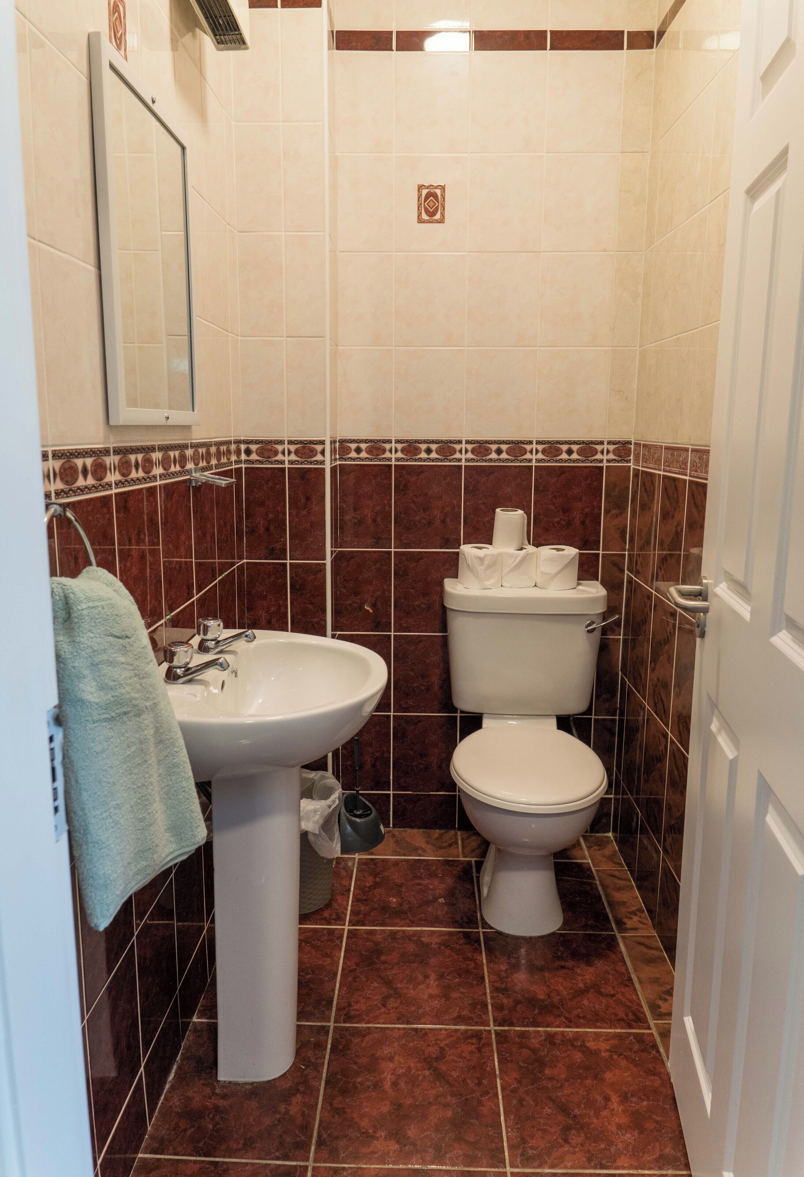 Ein Badezimmer mit Waschbecken, Toilette und Spiegel.